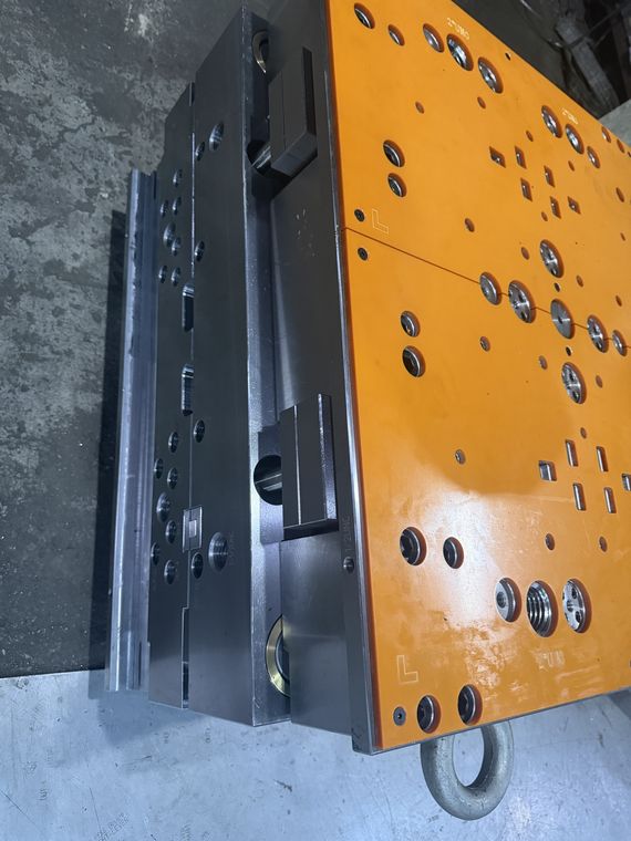 Plastic mold frame with orange side plates and lifting eye